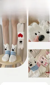 Close-up of thick coral fleece socks with cute cartoon 3D animal ears and heart patterns