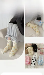 Detail of coral fleece cat socks showing embroidery and polka dots on thick fabric