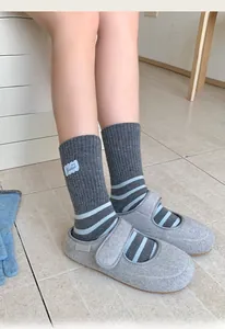 Detail of grey striped socks paired with velcro wool slippers in a cozy lifestyle setting