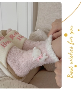 Detail of pink coral fleece socks featuring cute animal trim and ribbon bow decoration