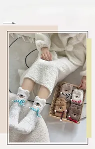Detail shot of cute bear fuzzy socks with 3D scarves in soft coral fleece texture