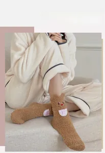 Detail showing plush coral fleece socks with cute bear pattern and fuzzy animal ears