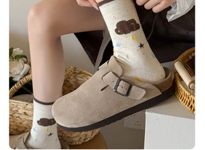 Detail of khaki suede clogs with metal buckle paired with cloud pattern knitted socks
