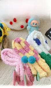 Detail of soft coral fleece socks with fluffy pom poms and thick plush texture for winter
