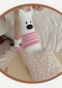 Close-up of fluffy white coral fleece socks with pink stripes and cute 3D polar bear detail
