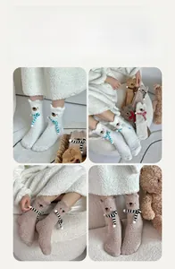 Close-up of cute 3D bear ears and stripe scarf embroidery on warm coral fleece socks