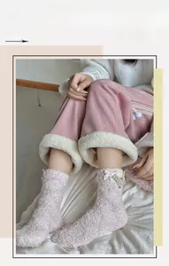 Detail of pink coral fleece socks with elegant pearl charms and bowknots for winter