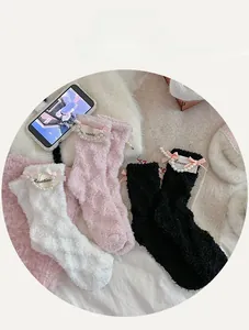 Detail of coral fleece socks featuring pearl charms and pink ribbon bows in three colors