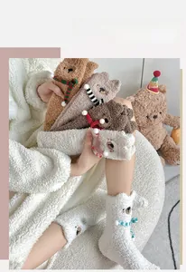 Close-up of thick bear-shaped coral fleece socks with 3D details and soft winter texture
