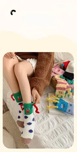 Detail of plush coral fleece socks featuring 3D monster design and colorful polka dots
