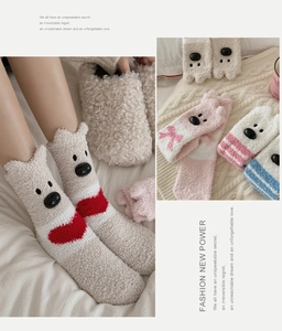 Detail of plush coral fleece winter socks with cute cartoon bear face and heart patterns