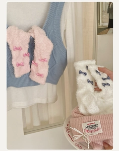 Detail of coral fleece socks with bow decoration and soft knitted texture for winter