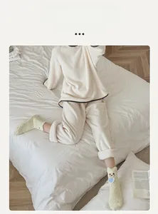 Detail of warm cream fleece loungewear set paired with soft green cartoon plush socks
