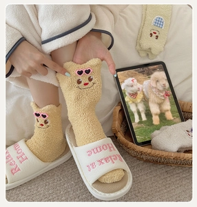 Detail of soft coral fleece winter socks with cartoon face and heart sunglasses design