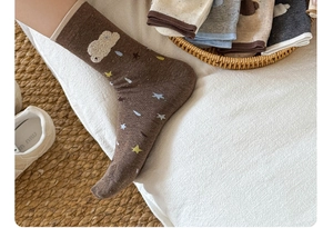 Close-up of brown cotton socks with soft flocking clouds and colorful star patterns