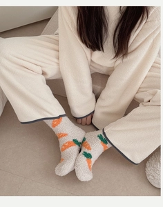 Gros plan de chaussettes d'hiver épaisses en polaire corail avec motif carotte mignon