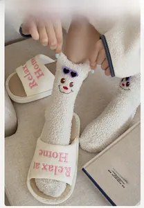 Close-up of cozy bear socks and slippers with Relax at Home embroidery details