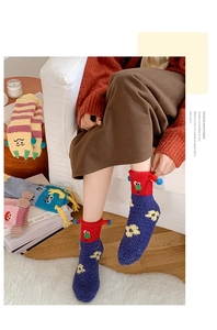 Detail of colorful cartoon coral fleece socks with 3D eyes and striped patterns