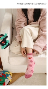 Detailed view of pink coral fleece socks featuring funny cartoon lips and eyes for winter