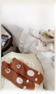 Close-up of cozy coral fleece socks with cute cartoon bear embroidery and 3D ears