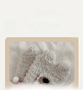Close-up of soft coral fleece socks showing elastic cuff and cute bear pattern detail