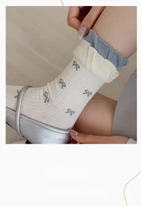 Detail of ballet style socks with bow pattern and triple layered frill cuffs in blue and white