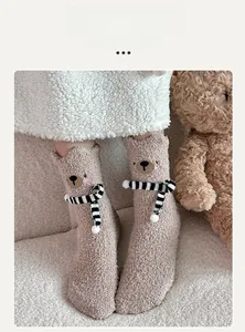 Close-up of thick coral fleece bear socks with 3D ears and striped scarf detail