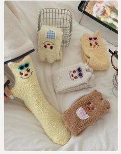 Close-up of thick coral fleece socks with cute cartoon embroidery and soft texture