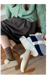 Detail showing various colors of knitted silk wool socks and texture on a model
