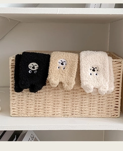 Detailed view of three pairs of thick coral fleece socks with cute cartoon embroidery