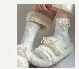Detail of coral fleece slippers and socks with pink ribbon bows and pearl accents