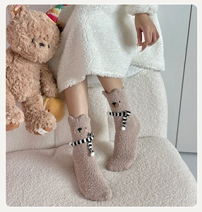 Close-up of thick bear-themed coral fleece socks with 3D ears and striped bow detail