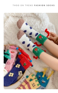 Detail showing colorful coral fleece socks with 3D cartoon elements and cute embroidery