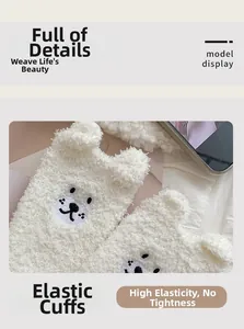 Close-up of white fleece socks featuring high-elastic cuffs and cute bear embroidery