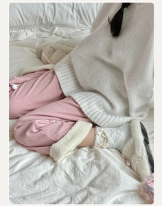 Detailed texture of fuzzy white socks paired with pink corduroy pants for loungewear