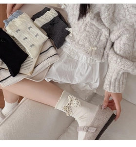 Detail of ruffled cuffs and polka dot bow accents on cozy ballet style crew socks