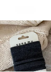 Macro detail of dark grey wool and silk socks showing the waffle knit texture and cuff
