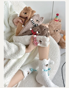 Close-up of thick bear-themed coral fleece socks with 3D decorative scarves and soft texture
