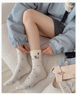 Detailed view of mid-calf socks featuring cute animal embroidery and polka dot patterns