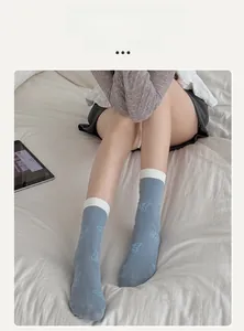 Detail of light blue crew socks with butterfly prints and white ribbed cuffs for women