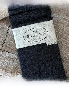 Close-up of gray silk wool waffle socks with branded paper packaging and knit texture