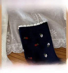 Close-up of navy floral cotton socks featuring high-elastic ribbed cuffs and wavy edges