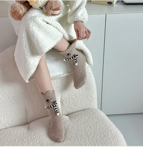 Detailed view of brown fuzzy bear socks with cute 3D ears and thick plush coral fleece texture