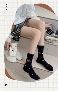 Detail of cute embroidered puppy and bow pattern on striped cotton crew socks for women