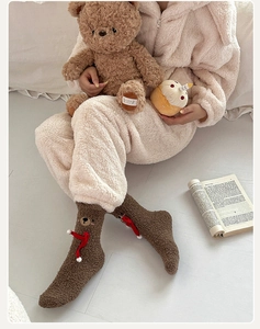 Detailed embroidery of bear head and red ribbon on plush brown winter warm coral fleece socks