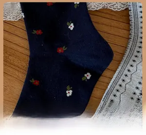 Detailed macro view of the reinforced toe on navy blue floral cotton crew socks