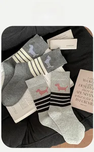 Close-up of cotton crew socks featuring cute dachshund patterns and classic striped accents