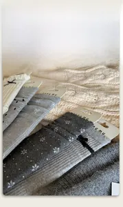 Detail view of assorted grey and beige winter crew socks with lace bows and polka dots