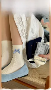 Detail of navy blue cotton socks with sweet bow knots and delicate floral patterns