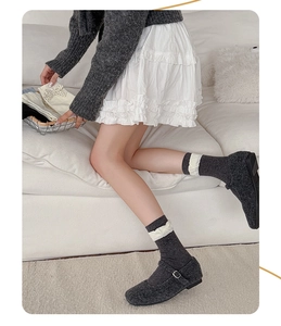 Detail of dark grey Mary Jane flats and matching socks with white ruffled lace trim